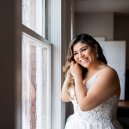 A bride puts on jewelry in the Lauren Suite at Revel 32°