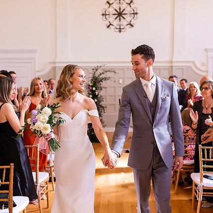 a happy ceremony ending with the bride and groom looking at each other lovingly as they walk back down the aisle together